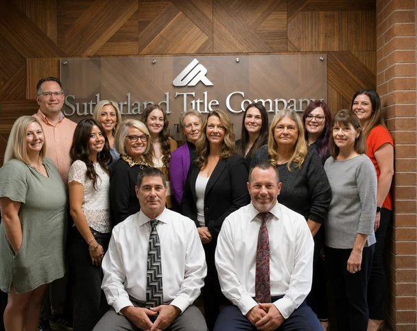 Sutherland Title Company team gathered in front of the office sign